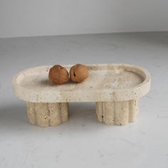 two walnuts sitting on top of a white table in the middle of a room