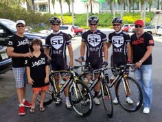 a group of men standing next to each other with bikes