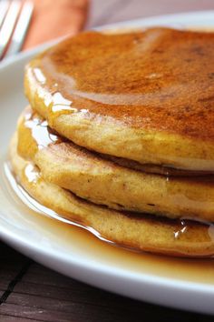 a stack of pancakes on a plate with syrup