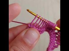 a person holding a small piece of yarn in their left hand and the end of a crochet hook on top of it