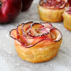 a pastry with powdered sugar on it sitting next to other pastries and fruit