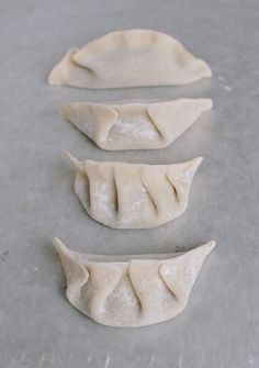 three dumplings sitting on top of a table next to each other in different shapes