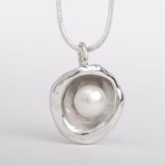 This "Aruba" pearl pendant necklace is handmade of 925 Sterling Silver. It has been hand crafted and cast in pure 92.5% solid silver in my workshop using a technique called water casting. I melt silver and pour the molten silver into cold water! The resulting organic shape creates a cup that imitates nature in a beautiful way. Finally, the lovely cultured pearl is set inside the cup to create this unique pendant.Pearl color: white Pendant size: approx 3/4 inch (20 mm) diameter The pendant hangs Handmade Sterling Silver Pearl Necklace With Round Pendant, Handmade Silver Pearl Necklace With Round Pendant, Unique Sterling Silver Pearl Necklace Gift, Handmade Sterling Silver Pearl Pendant Necklace, Handmade Sterling Silver Pearl Necklace In Silver, Handmade Sterling Silver Pendant Pearl Necklace, Dark Siren, Chunky Silver Jewellery, Silver Clay