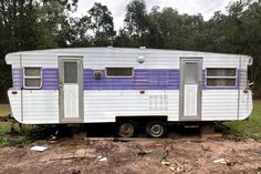 an old trailer is parked in the dirt