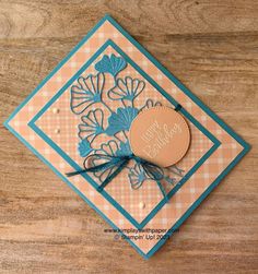 a close up of a card on a wooden surface with a ribbon around the edge