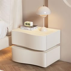 a night stand with two drawers and a clock on it in the corner of a room