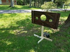 a small wooden object in the grass near a tree