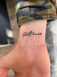 a person with a small tattoo on their wrist that says,'patience'in cursive writing