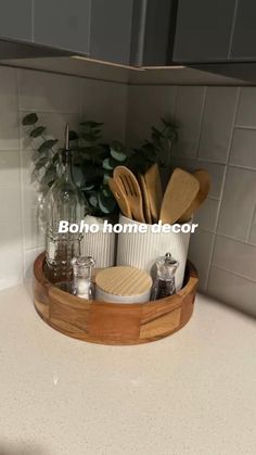 a wooden tray with utensils and spoons in it on a kitchen counter