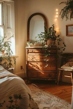 a bedroom with a dresser, mirror and plants on the floor in front of it