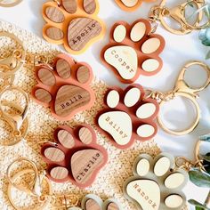 many different types of key chains with dog's paw prints and names on them