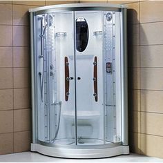 a corner walk in shower with two doors on the side and brown tile walls behind it