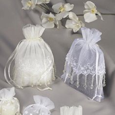 white wedding favors and garters on a gray background with orchids in the bag