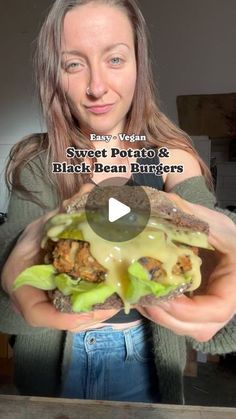 a woman holding a large hamburger in her hands with the caption sweet potato & black bean burgers