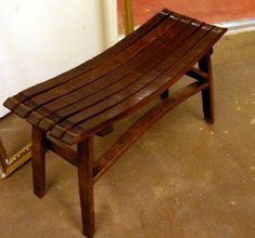 a wooden bench sitting on top of a cement floor