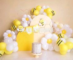 a table topped with lots of balloons and bees