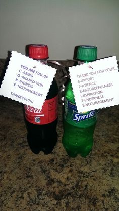 two bottled water bottles sitting on top of a counter with thank cards attached to them