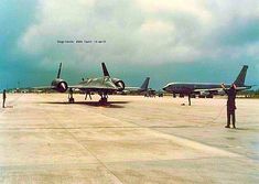 two planes parked on the tarmac with people standing near them and looking at them