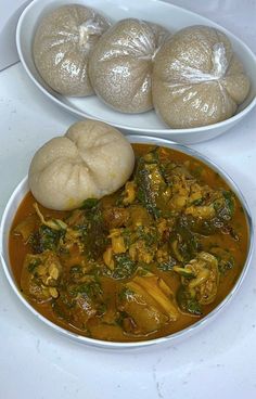 two bowls filled with food next to each other on a white counter top and one bowl has dumplings in it