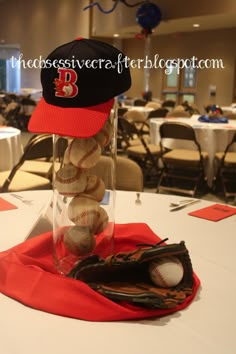 baseballs in a glass vase on top of a table