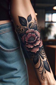 a woman's arm with a flower tattoo on the left side of her arm