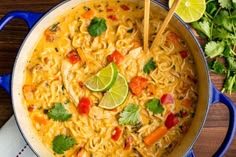 a blue pot filled with soup and garnished with cilantro