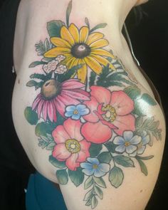 a woman's stomach with flowers and leaves painted on the back of her body