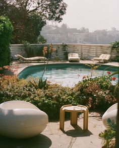 an outdoor swimming pool surrounded by plants and flowers