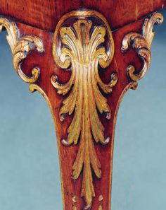 an ornately carved wooden table with gold leaf decoration on the top and bottom edge