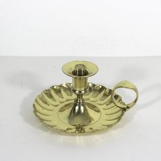 a brass candle holder on a white table