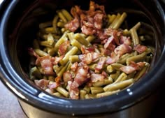 a crock pot filled with green beans and bacon