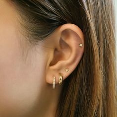 a close up of a woman's ear with two small diamond studs on it