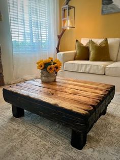 a coffee table made out of pallet wood with sunflowers sitting on top