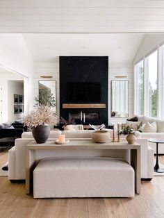 a living room filled with furniture and a fire place in the middle of a room