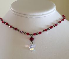 "Ruby red crystal choker wire wrapped in vintage bronze with Swarovski Crystal AB teardrop focal. Perfect for layering with other pieces or stunning alone! Gorgeous 4mm Fire Polished Siam Red AB crystals are wire wrapped in vintage bronze with stunning 13mm faceted Swarovski Crystal AB teardrop focal. Necklace is made to be worn as a choker and measures 16\" with a 2\" vintage bronze extension chain. Closes with bronze lobster claw clasp and has tiny red Crystal dangle on the end for fun! Comes Paris Charm Bracelet, Ruby Red Necklace, Chain Art, Red Crystal Necklace, Czech Glass Jewelry, Beautiful Baubles, Red Beaded Necklaces, Necklace Swarovski, Aesthetic Jewelry