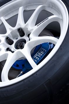 the wheel and tire of a car with blue brake pads on it's rim