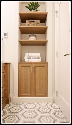 a bathroom with wooden shelves and towels on top of each shelf in front of the door