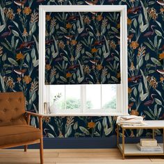 a living room with blue wallpaper and a window that has birds on the leaves