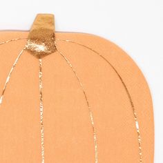 a paper pumpkin with gold foiling on it's sides and a string attached to the top