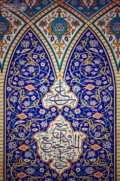 an intricately decorated wall with arabic calligraphy in blue and orange colors, on display at the alhambra