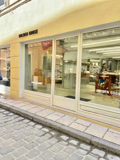 a woman walking down the sidewalk in front of a store