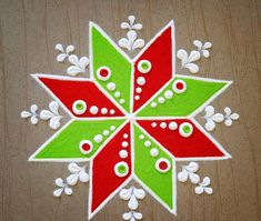 a red, green and white christmas ornament on a wooden surface