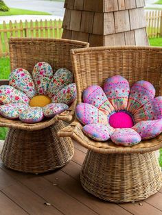 two wicker chairs sitting on top of a wooden deck covered in pillows and cushions