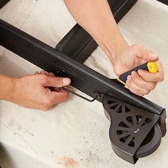 a person is using a tool to fix a piece of metal that has been placed on the ground