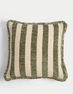 a green and white striped pillow sitting on top of a wall