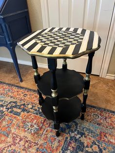 a black and white checkerboard table sitting on top of a rug