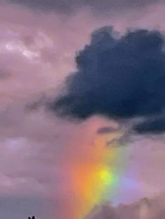 there is a rainbow in the sky with clouds