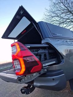 the back end of a car with its trunk open and it's tail light on