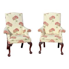 pair of upholstered chairs with red and white flowers on the backrests