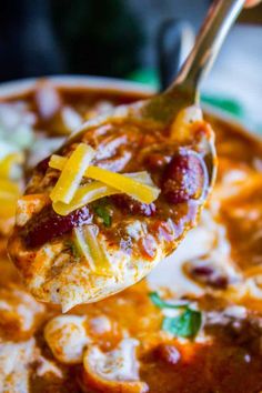 a spoon full of chili and cheese soup